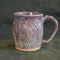 Ceramic mug with textured design on a dark background