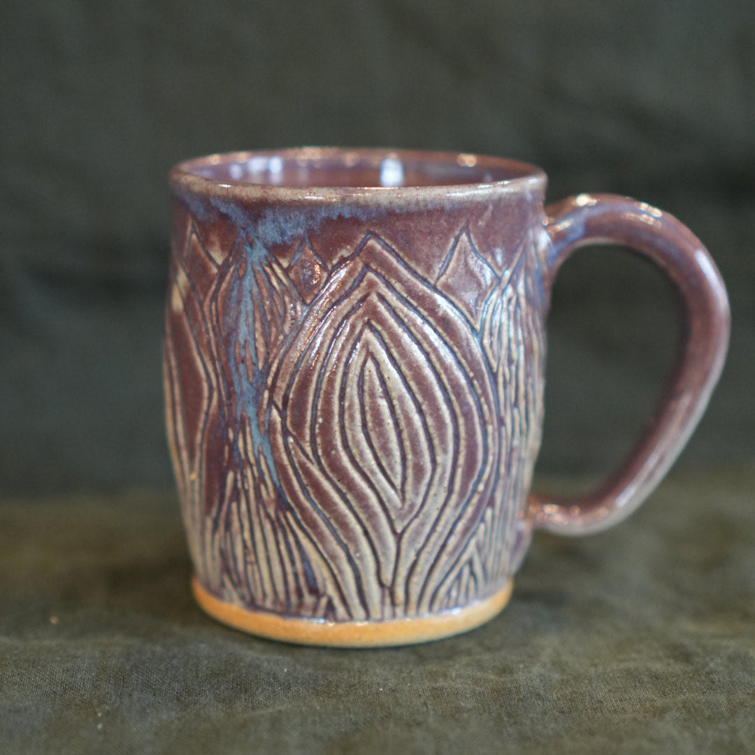 Ceramic mug with textured design on a dark background